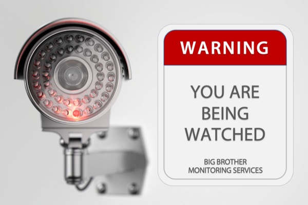 Image of a surveillance camera and a sign saying you are being watched