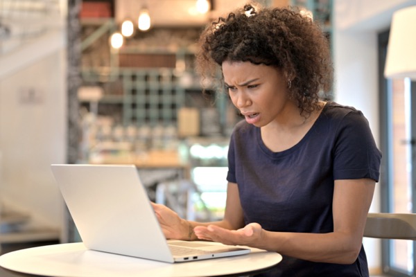 Woman staring in frustration and disbelief at the screen of a laptop computer