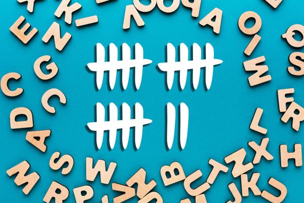 Image of wooden letters surrounding white tally marks against a teal background, representing font usage reports in FontAgent Server